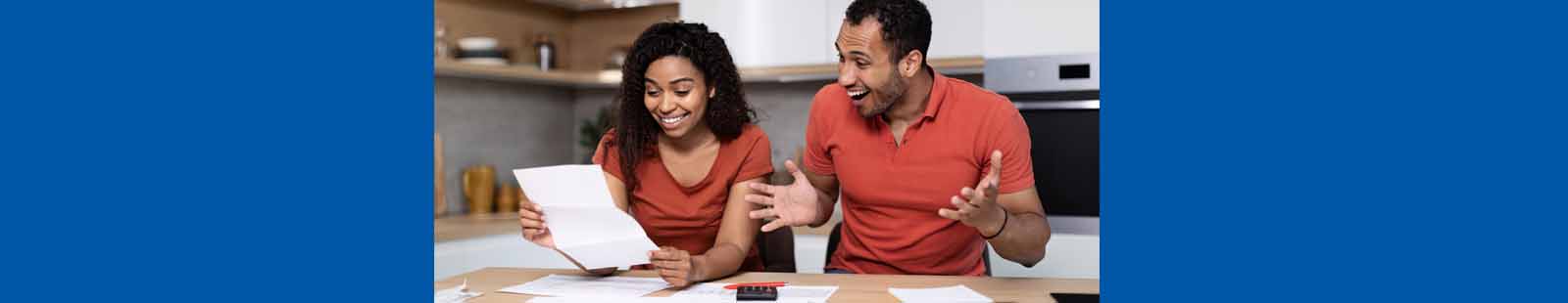 Man and woman looking at their statement with smiles on their face