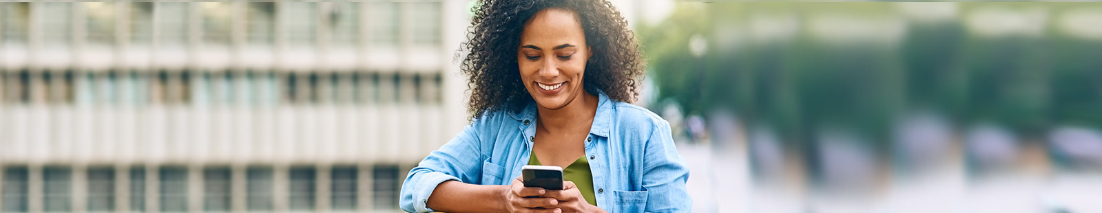 Lady looking at her phone with a smile.