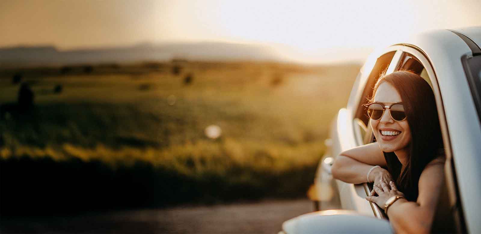 woman in a car smiling out the window