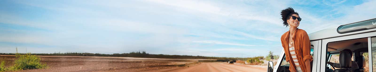 woman hanging outside her car window smiling
