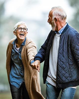 Mature adults walking in park.